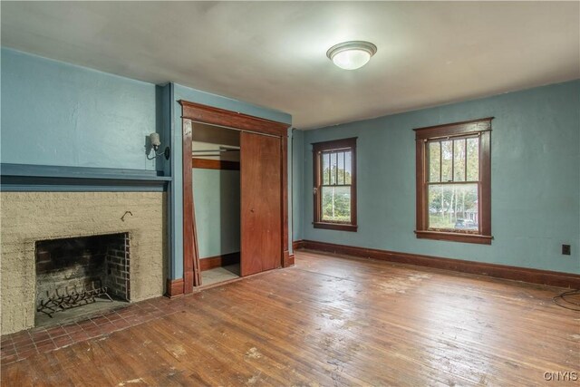 12 Academy St, Antwerp, NY 13608 - unfurnished living room featuring baseboards, hardwood / wood-style flooring, and a fireplace