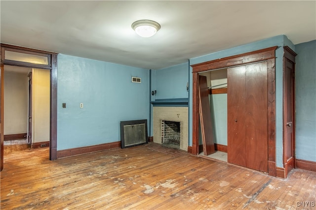 unfurnished living room featuring a fireplace and hardwood / wood-style floors