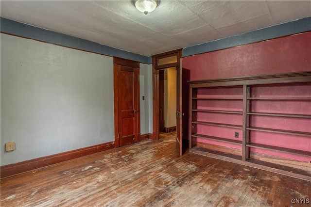 unfurnished bedroom with dark hardwood / wood-style flooring