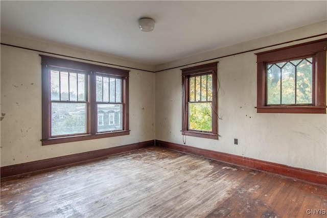 empty room featuring hardwood / wood-style floors and baseboards