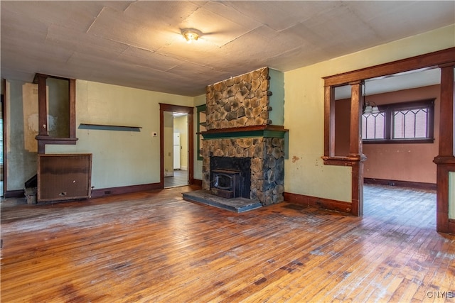 unfurnished living room with a wood stove and hardwood / wood-style flooring