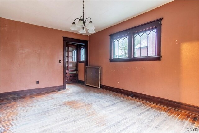 12 Academy St, Antwerp, NY 13608 - empty room with a chandelier, baseboards, and wood finished floors