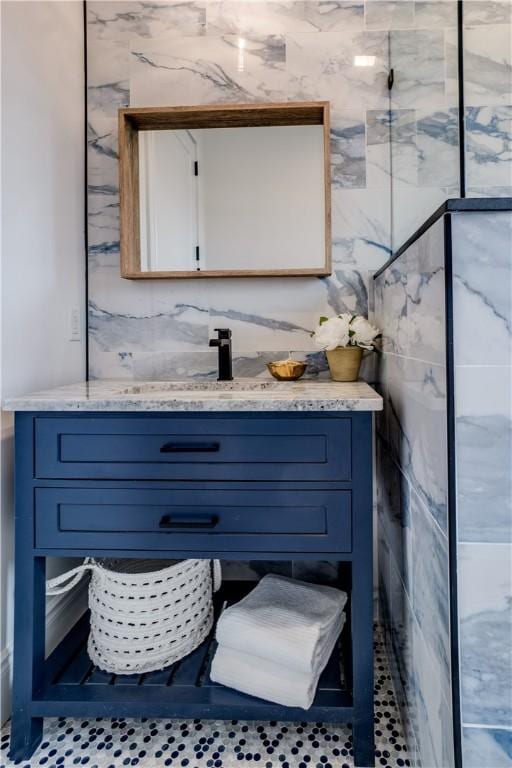 bathroom featuring vanity and tile walls