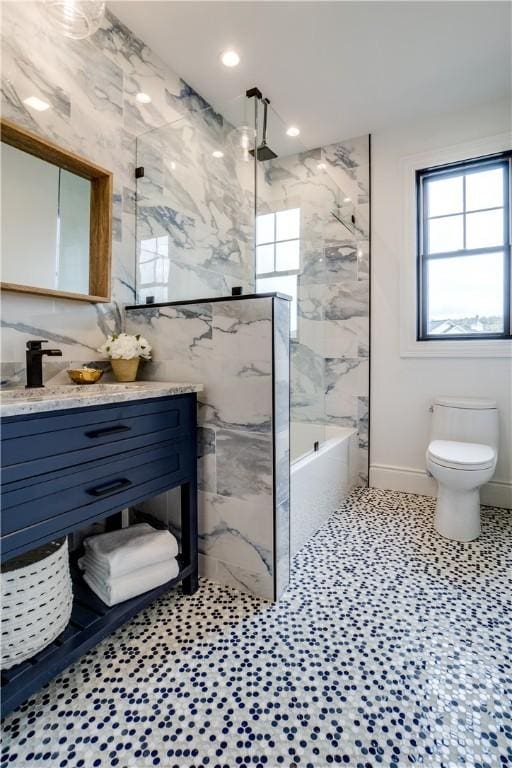 bathroom featuring toilet, vanity, and tiled shower