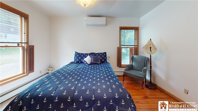 bedroom featuring dark hardwood / wood-style flooring, multiple windows, an AC wall unit, and a baseboard heating unit