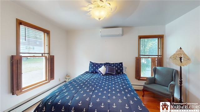 bedroom featuring dark hardwood / wood-style flooring, an AC wall unit, and baseboard heating