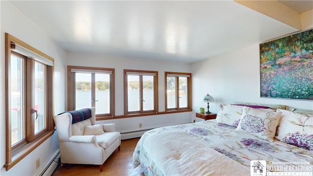 bedroom with a baseboard radiator and light hardwood / wood-style flooring