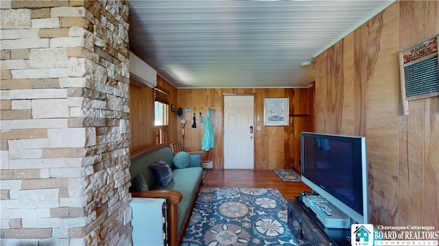 interior space featuring an AC wall unit, wood walls, and hardwood / wood-style flooring