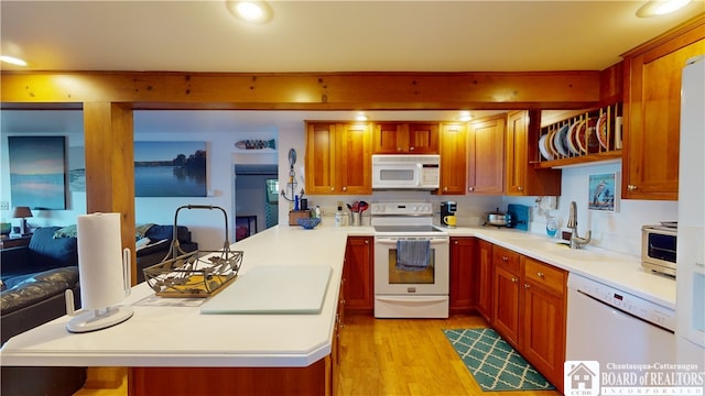 kitchen featuring kitchen peninsula, white appliances, sink, and light hardwood / wood-style flooring