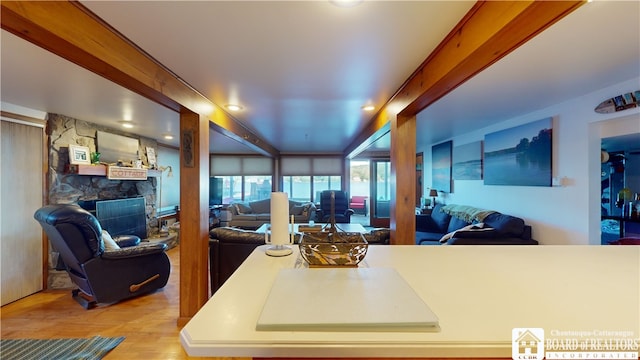 kitchen with light hardwood / wood-style floors and a stone fireplace