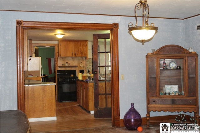 kitchen featuring decorative light fixtures, white refrigerator, stove, crown molding, and dark hardwood / wood-style floors