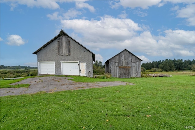 exterior space with a front lawn, an outdoor structure, and a garage