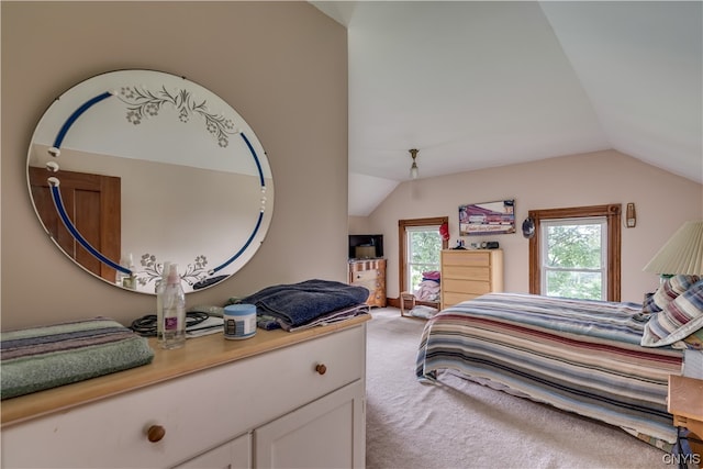 bedroom with multiple windows, lofted ceiling, and light carpet