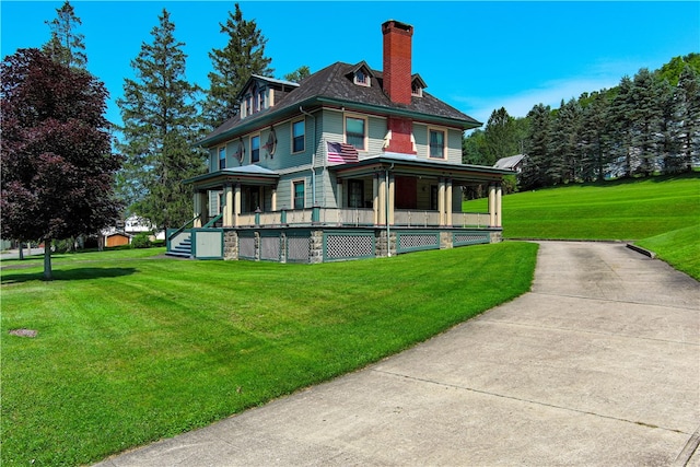 back of house featuring covered porch and a lawn