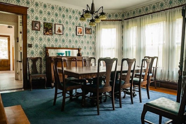 dining space featuring ornamental molding, a chandelier, and plenty of natural light