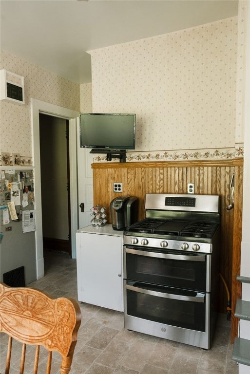 kitchen featuring tile flooring, gas stove, and fridge