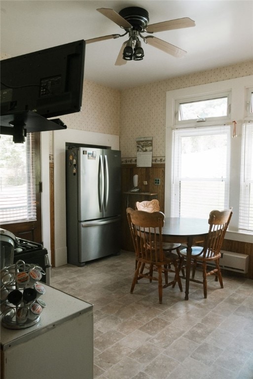 tiled dining space with plenty of natural light and ceiling fan