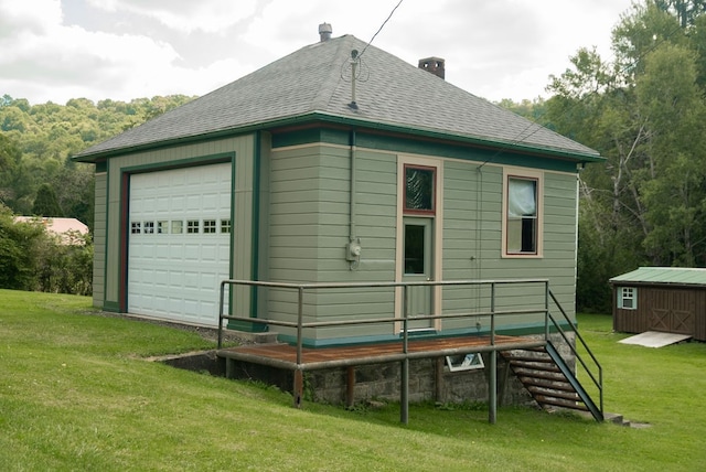 rear view of house featuring a lawn and a storage unit