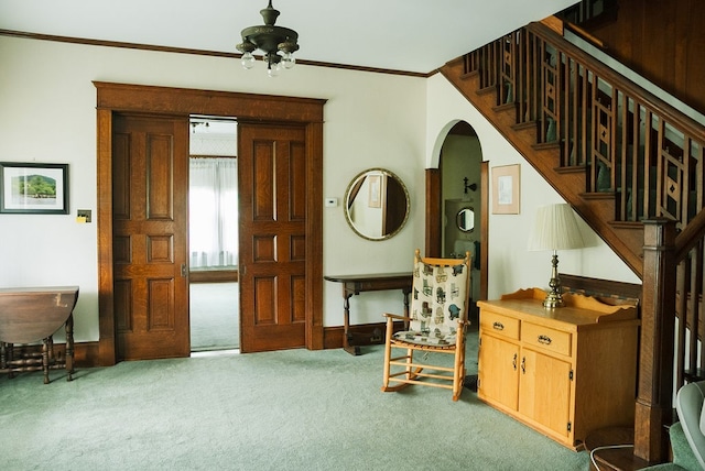 interior space with carpet flooring, ceiling fan, and ornamental molding