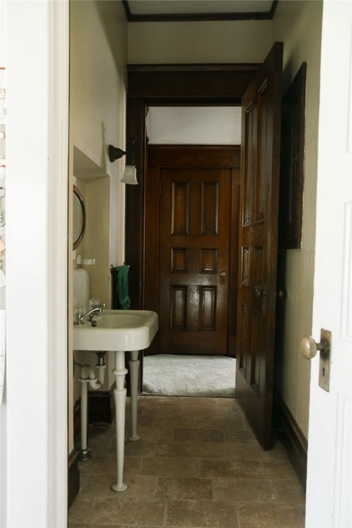 hall with dark carpet and ornamental molding