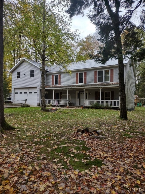 view of front of home with a porch, a front yard, and a garage