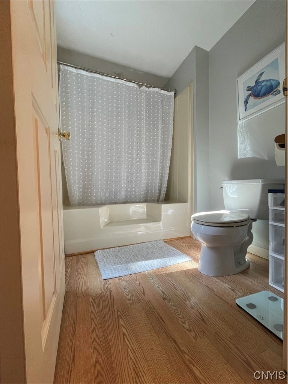 bathroom featuring shower / bath combination with curtain, toilet, and hardwood / wood-style floors