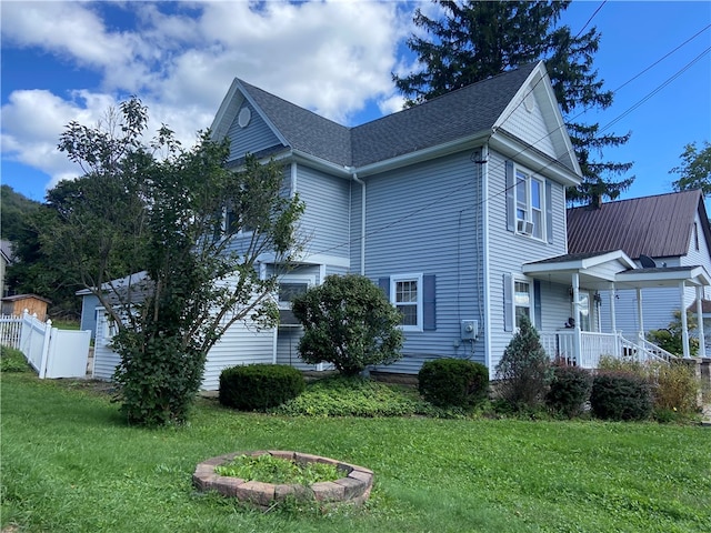 view of side of home with a yard and a porch