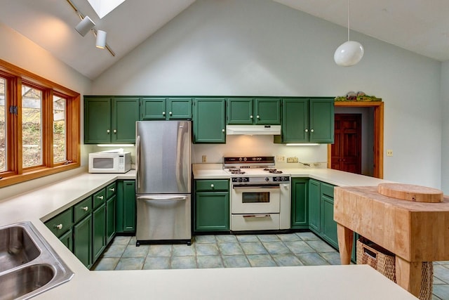 kitchen with light tile floors, high vaulted ceiling, green cabinetry, white appliances, and hanging light fixtures