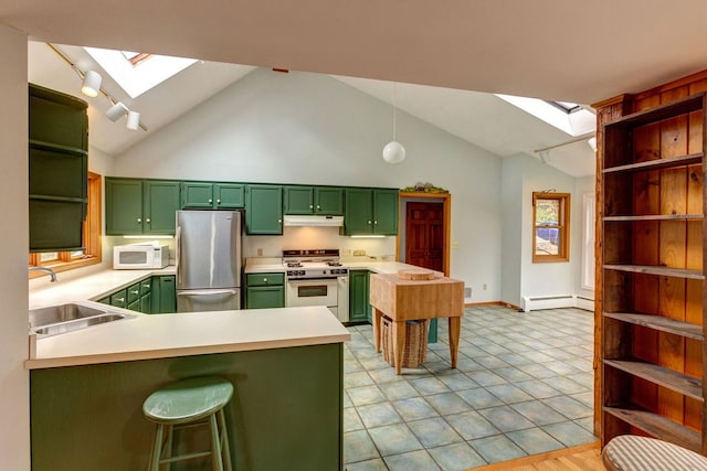 kitchen featuring light tile flooring, a kitchen bar, a skylight, white appliances, and sink