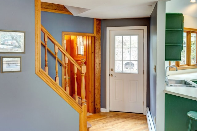 doorway featuring light hardwood / wood-style flooring, a baseboard heating unit, and sink