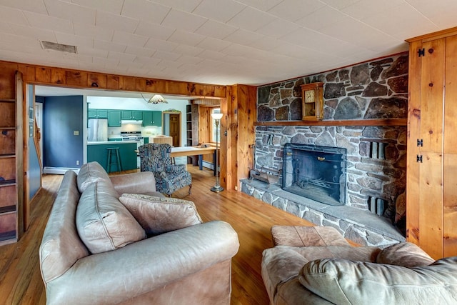 living room featuring a fireplace, wood walls, and hardwood / wood-style flooring