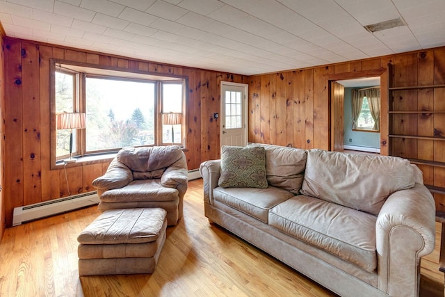 living room featuring a healthy amount of sunlight, light hardwood / wood-style flooring, and baseboard heating