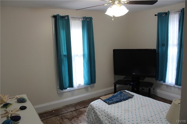 bedroom with wood-type flooring, multiple windows, and ceiling fan