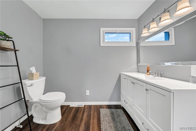 bathroom with toilet, hardwood / wood-style floors, and oversized vanity