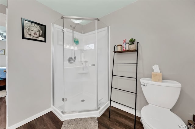 bathroom with walk in shower, toilet, and hardwood / wood-style flooring