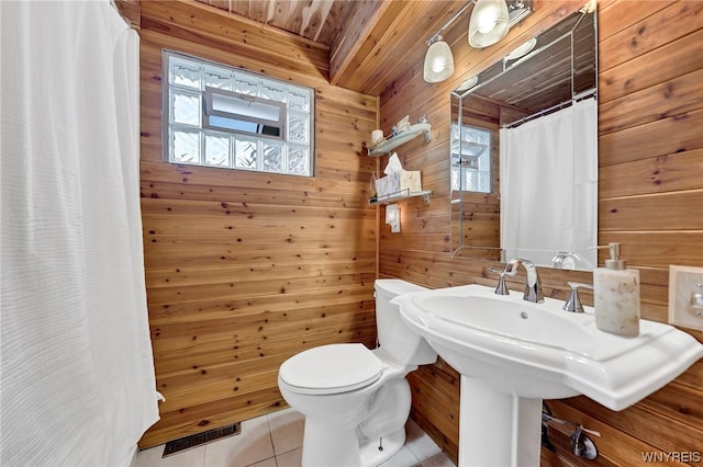 bathroom with tile floors, toilet, wooden ceiling, and wood walls