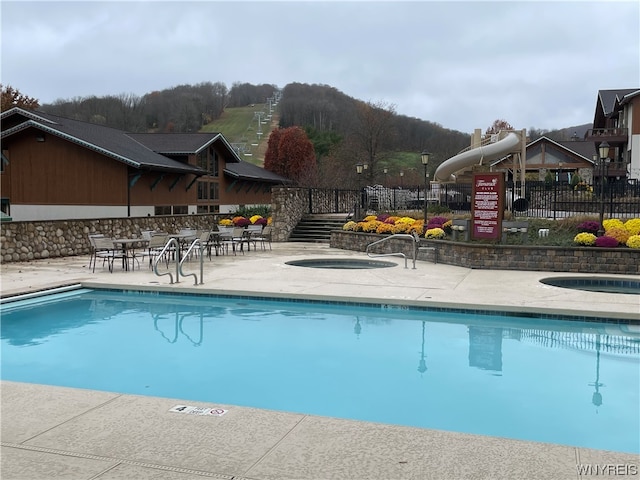 view of pool with a community hot tub and a patio