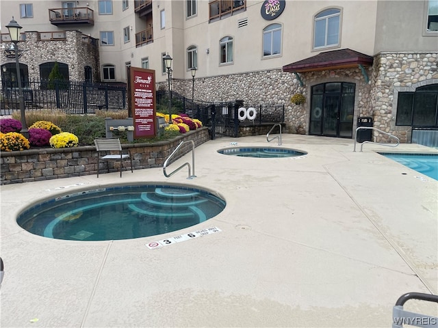 view of pool with a patio and a hot tub