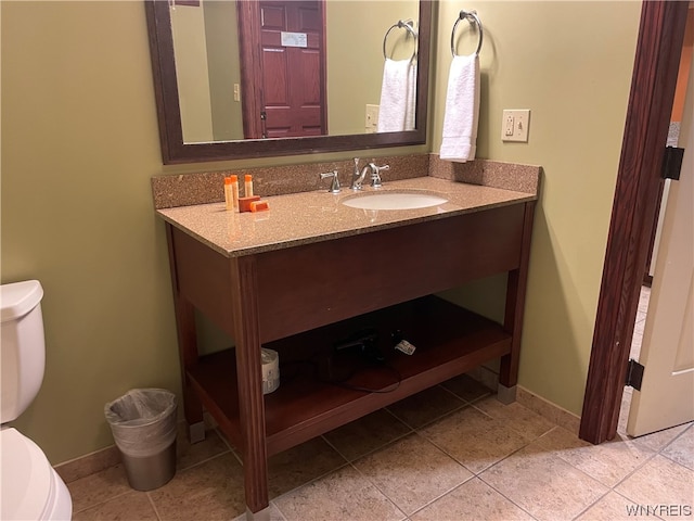 bathroom featuring vanity, tile flooring, and toilet