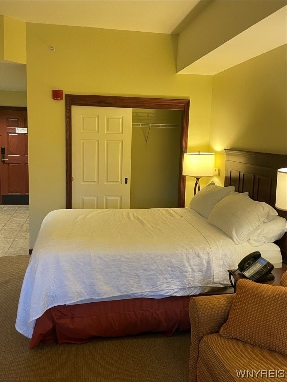 bedroom featuring a closet and light tile floors