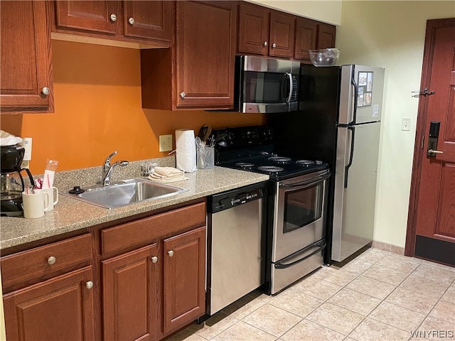 kitchen featuring appliances with stainless steel finishes, light tile floors, and sink