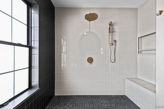 bathroom featuring plenty of natural light, tile flooring, tile walls, and tiled shower