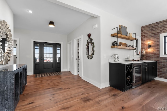 foyer featuring beverage cooler, brick wall, and dark hardwood / wood-style floors