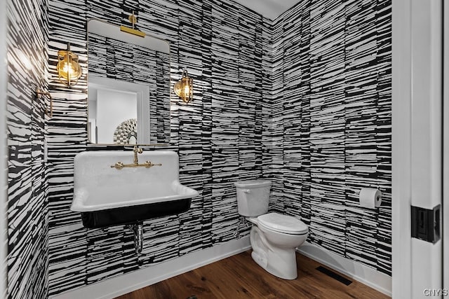 bathroom with sink, hardwood / wood-style floors, toilet, and tile walls