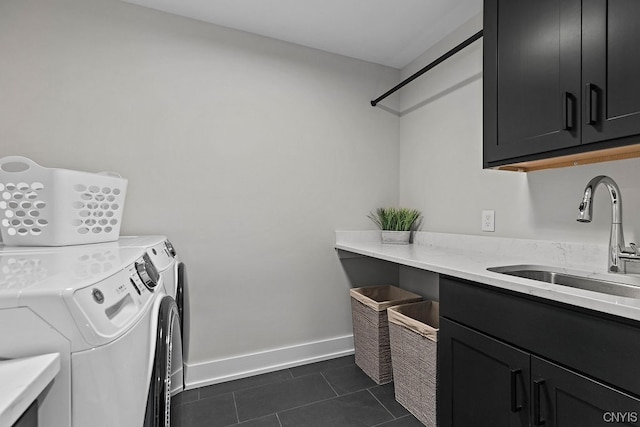 washroom with dark tile flooring, independent washer and dryer, cabinets, and sink