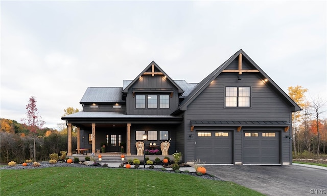 view of front facade with a porch, a front yard, and a garage