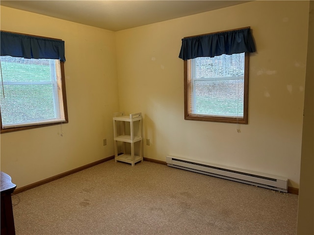 carpeted empty room with a baseboard heating unit