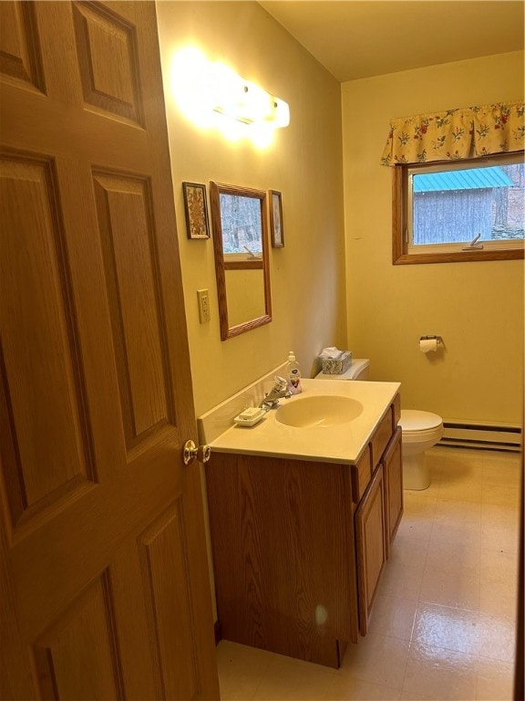 bathroom with tile floors, baseboard heating, vanity, and toilet