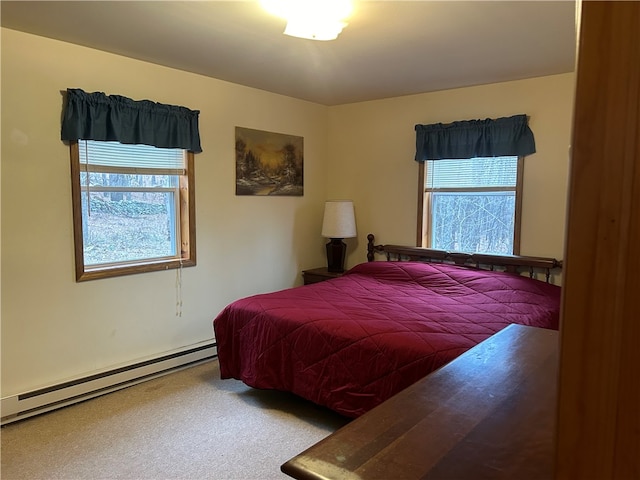 bedroom featuring a baseboard heating unit, multiple windows, and carpet flooring