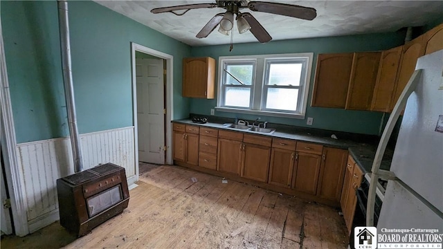 kitchen featuring white refrigerator, sink, black electric range, ceiling fan, and light hardwood / wood-style floors